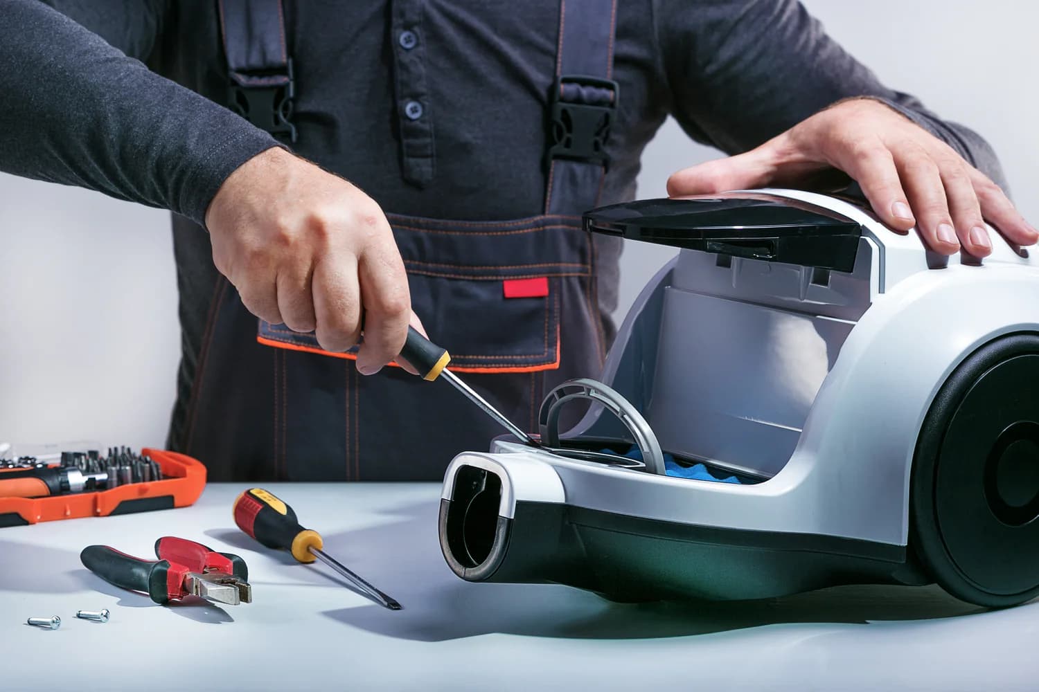 photo d'un homme réparant un aspirateur